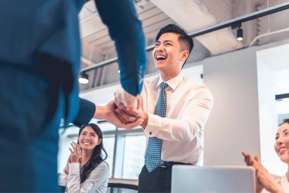 A man shaking hands with someone in the office