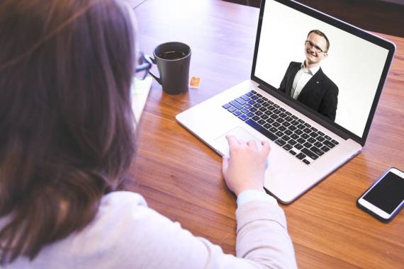 a woman having an online meeting with someone with her laptop